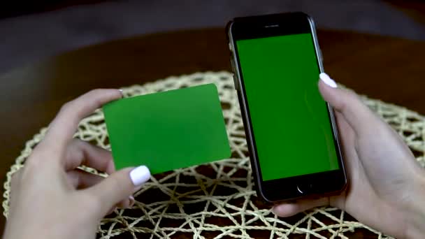 Kredi kartı ve telefonu olan bir kız. Verileri kapatır. Yeşil Ekran — Stok video
