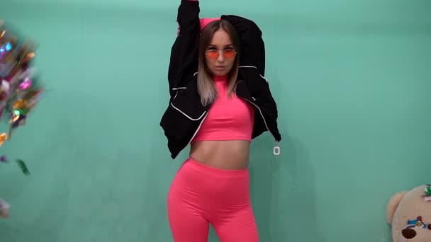 Confetti vuela delante de una chica de moda en ropa rosa — Vídeos de Stock