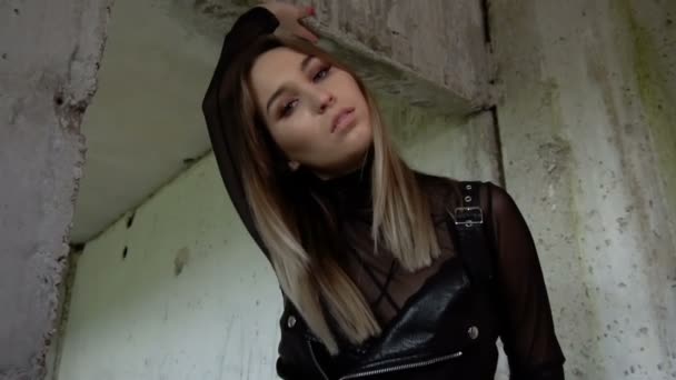 Bruut meisje in een verlaten gebouw. Model in zwart lederen kleding — Stockvideo