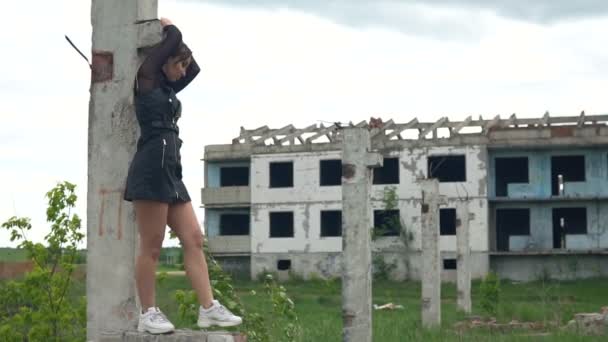 Ragazza sullo sfondo di un edificio abbandonato. Capelli svolazzanti nel vento. Rallentatore — Video Stock