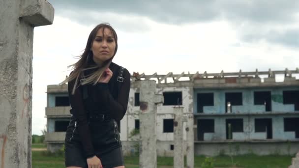 Chica en el fondo de un edificio abandonado. Cabello revoloteando en el viento. Movimiento lento — Vídeo de stock