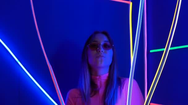 Módní dívka v růžovém oblečení na pozadí neonových lamp — Stock video