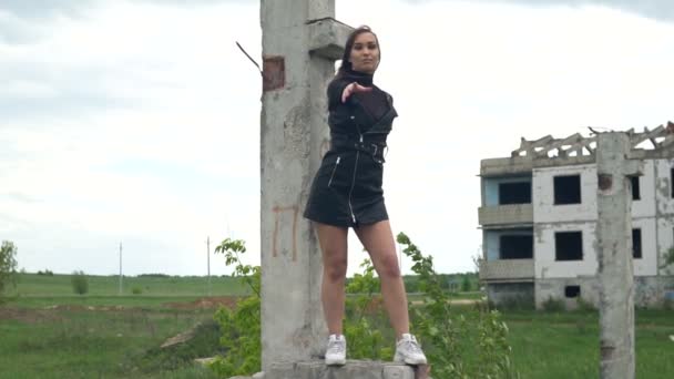 Lánytánc egy elhagyatott épület hátterében. Szőrszálhasogatás a szélben. Lassú mozgás. — Stock videók