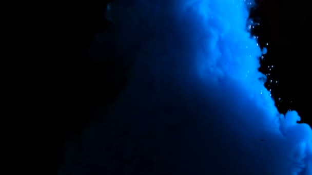 Настоящие голубые капли краски в воде в инверсии замедленной съемки. Чернила кружатся под водой. Облако столкновения чернил изолировано на черном фоне с альфой. Закрыть вид — стоковое видео