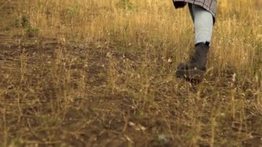 Genç bir kadın yokuş yukarı çıkıyor. Palto giyen kız.