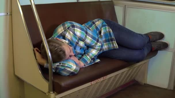 Молодой человек заснул в поезде метро. Старый вагон метро — стоковое видео