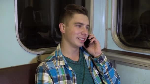 Un joven habla por teléfono en un tren subterráneo. Viejo vagón de metro — Vídeos de Stock