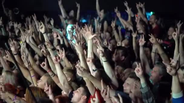 Samara, Ryssland - 29 september 2019: En folkmassa på en musikkonsert höjde sina händer. En skrattande publik framför ljusa färgglada scenljus — Stockvideo