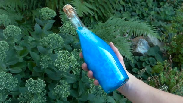 Пляшка синя Еліксир в руці — стокове відео
