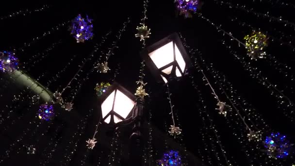 Lamppost alrededor colgando bombillas luminosas en la calle por la noche — Vídeos de Stock