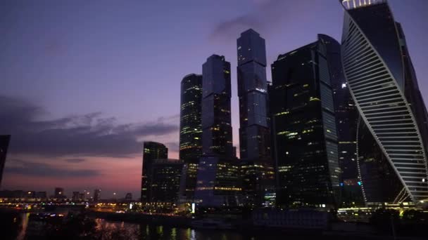 Skyskrapere står bak elven ved solnedgang. Moskva by – stockvideo