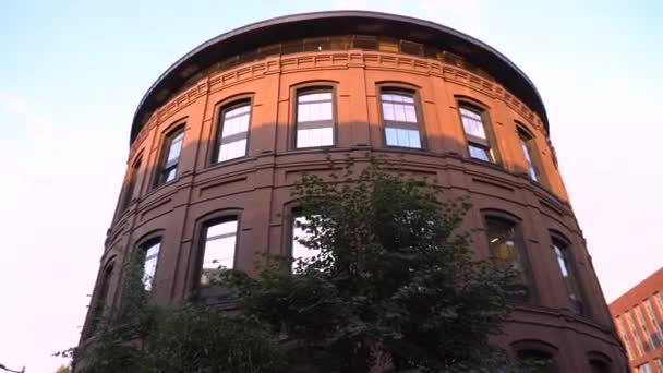 Grand bâtiment en forme de cylindre. Vue de derrière les buissons — Video