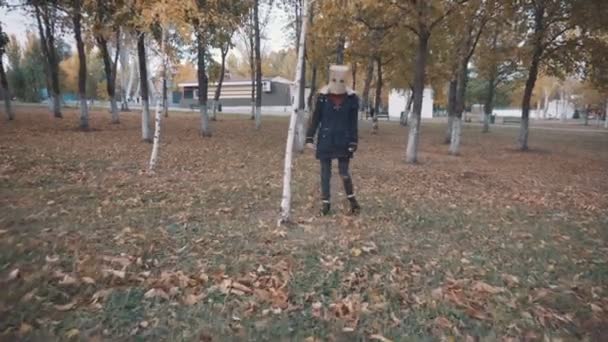 Una ragazza con un branco in testa si nasconde dietro un albero. Ragazza in giacca — Video Stock