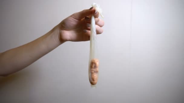 Dziewczyna trzymająca prezerwatywę z embrionalnym dzieckiem — Wideo stockowe