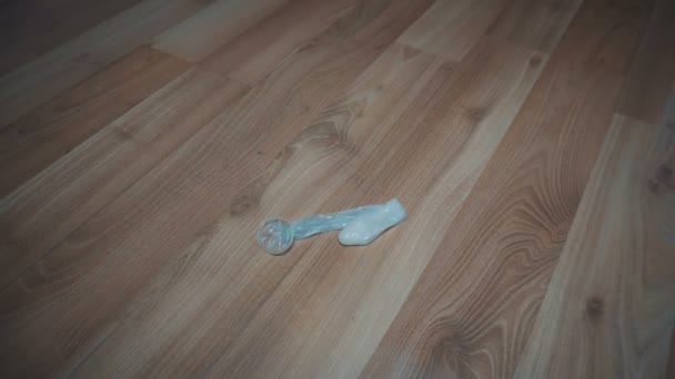 Buttare via il preservativo usato sul pavimento — Video Stock