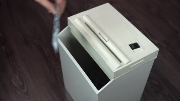 Shredder distrugge una banconota da cento dollari. Un uomo spinge i soldi in un trituratore di carta — Video Stock