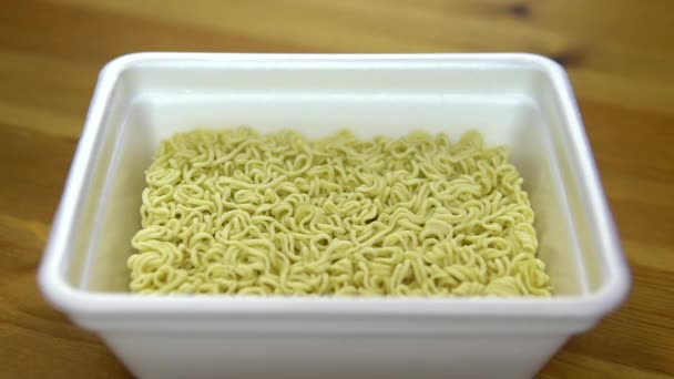 In de instant noedels gevuld met kruiden. Ramen in een speciale plastic plaat. Langzame beweging — Stockvideo