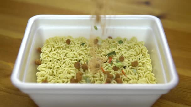 Nel momento tagliatelle spezie backfilled. Ramen in un piatto di plastica speciale. Rallentatore — Video Stock