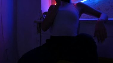 Neon arka planda telefonla konuşan bir kız. Şık giyinmiş kız.