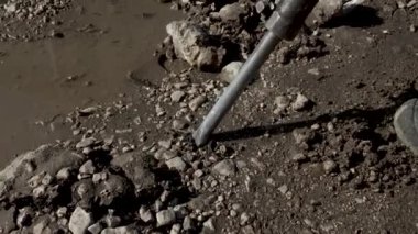 Kaya matkabıyla çalışan bir adam. Bir kaya matkabı asfaltı kırar. Büyük ve ağır yol onarım aletleri. Yavaş çekim