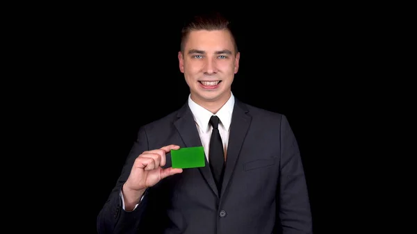 Der junge Geschäftsmann präsentiert eine grüne Karte und zeigt wie mit der Hand. chromakey green card. — Stockfoto