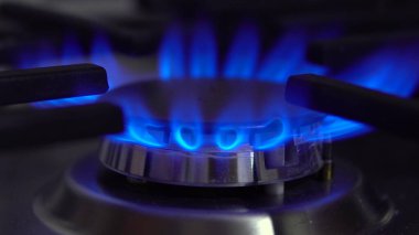 Ocaktaki gaz ocağı yanıyor. Alev mavi.