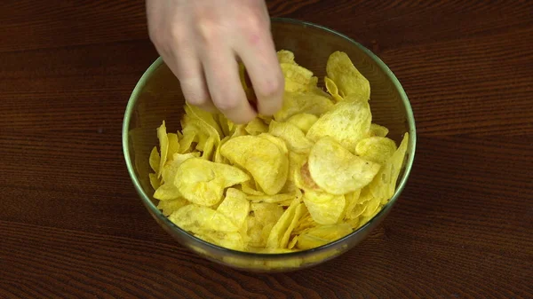 Les mains des gens qui prennent activement des chips d'un grand plat. La compagnie d'amis mange des croustilles. Les mains en l'air. Les affamés — Photo