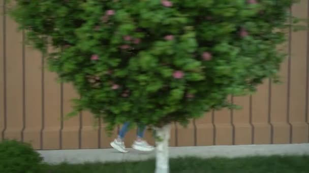 En ung kvinna springer nära ett köpcentrum. Flickan är sen och springer. Tillfälligt slitage. — Stockvideo