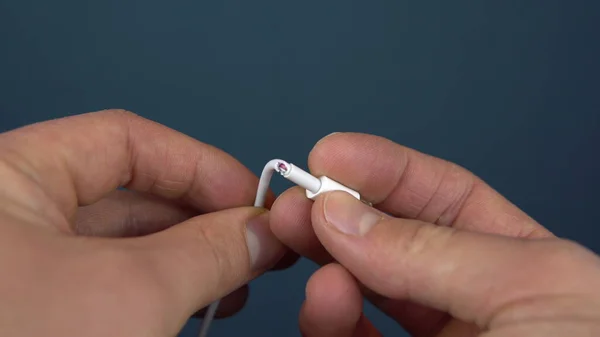 Primer plano del cable del cargador del teléfono roto. Un hombre tiene un alambre roto en sus manos. Desgaste de alambre — Foto de Stock