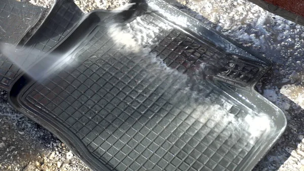 Lava la suciedad de una alfombra de coche con un chorro de agua de alta presión. Detergente especial para lavado de autos . — Foto de Stock