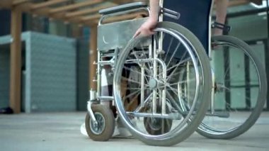 Tekerlekli sandalyedeki genç kadın. Tekerlekli sandalyeye yakın mesafeden binen bir kız. Engelliler için özel taşıma.