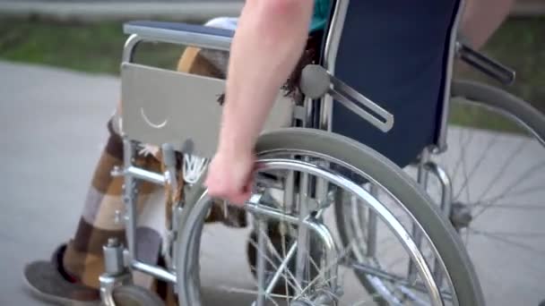 Un joven en silla de ruedas. Un hombre monta en una silla de ruedas de cerca. Transporte especial para minusválidos . — Vídeos de Stock