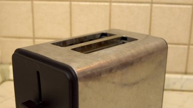 Kahvaltıda kızarmış ekmek yapmak için tost makinesi. Mutfakta elektrikli alet var.