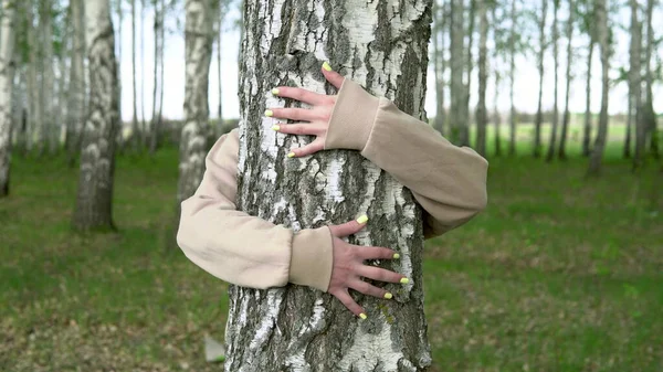 A young woman hugs a birch. The girl is worried about nature and shows love for her. — Stock Photo, Image