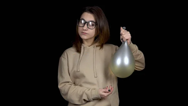 Mujer joven sacude las bolas con agua. Chica sacude la pelota sobre un fondo negro. El globo tiembla como gelatina . — Foto de Stock