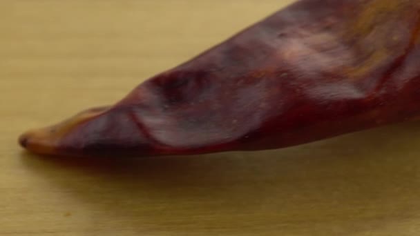 Hele chili pepers op een houten ondergrond. Bewegend platform met paprika 's macro shot. — Stockvideo