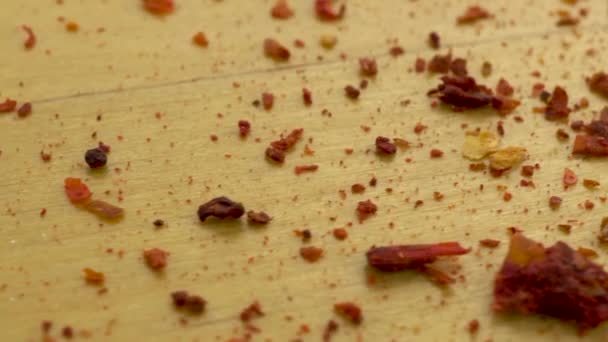 Αλεσμένες πιπεριές τσίλι σε ξύλινη επιφάνεια. Κινούμενη πλατφόρμα με μακροεντολή πιπέρι. — Αρχείο Βίντεο