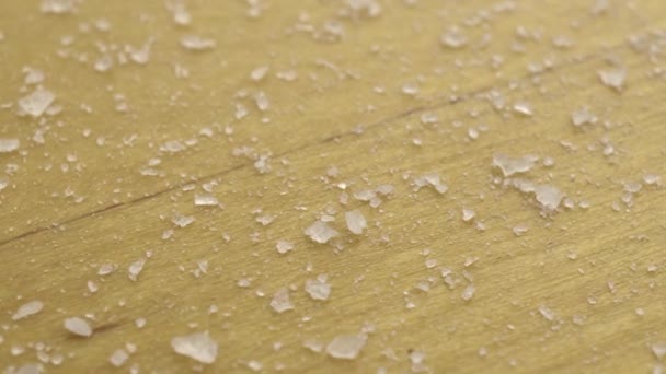 Salt on a wooden surface. Moving platform with salt crystals. — Stock Video