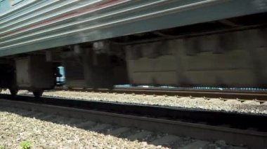 Yolcu treni geçiyor. Tekerleklerin yan görüntüsü. İnsanları taşımak için demiryolu taşımacılığı.