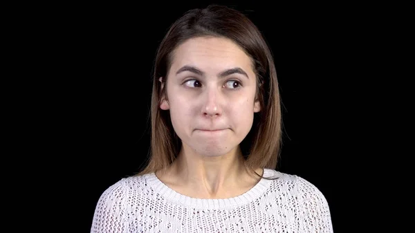 Genç kadın yüzünde korku dolu duygular gösteriyor. Bir kadın korkudan titrer ve siyah bir arkaplana bakar..