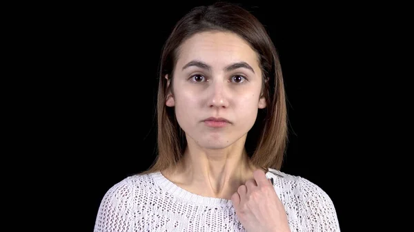 Die junge Frau zeigt Gefühle der Angst im Gesicht. Eine Frau zittert vor Angst und sieht sich auf schwarzem Hintergrund in Großaufnahme um. — Stockfoto