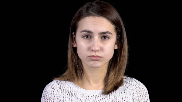 Een jonge vrouw toont emoties van verdriet op haar gezicht. De vrouw is verdrietig op een zwarte achtergrond closeup. — Stockfoto
