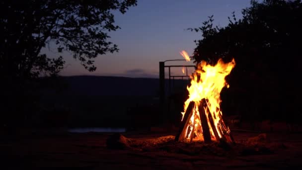 Un feu de joie brûle au milieu de la nuit. Feu sur le fond de la rivière et des montagnes. — Video