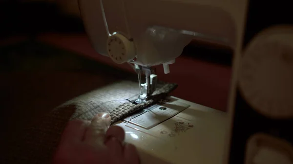 Em uma máquina que cose cosem a roupa close-up. Vestidor costura tecido . — Fotografia de Stock