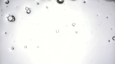 Deterjan cama sıkılır ve bir bez ile silinir. Baloncuklar bir araya toplanmış. Toprak ve tozdan cam temizleme. Makro alt görünüm.