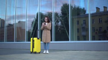 Bavullu çekici genç bir kadın kayboldu. Kız telefonda haritaya bakıyor ve bir yol arıyor..