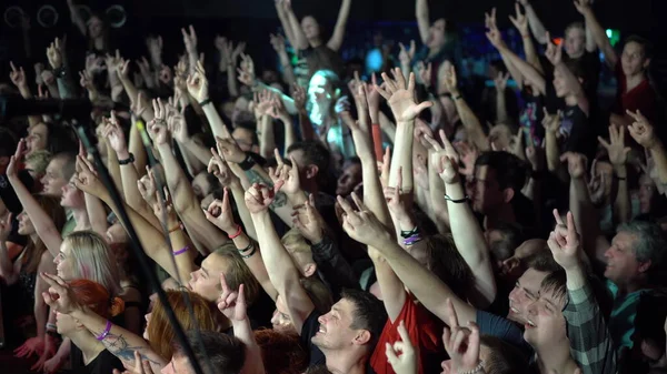 Samara, Oroszország - 2019. szeptember 29.: Egy zenei koncerten emberek tömege tette fel a kezét. A nevető tömeg előtt fényes színes színpadi fények — Stock Fotó