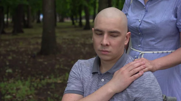 Una mujer pone su mano en el hombro de un joven con cáncer en apoyo. El hombre pone su mano sobre la mano de las mujeres. Pérdida de cabello debido a quimioterapia. —  Fotos de Stock