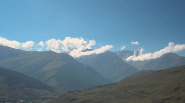 Yeşil bulutlu Kafkasya dağlarının panoramik manzarası. Kamera soldan sağa hareket ediyor..