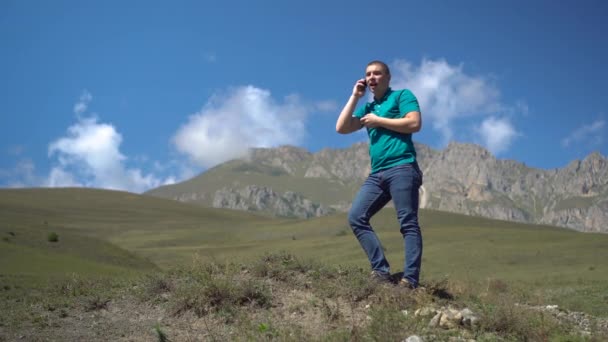 Mladý muž hledá mobilní síť v Kavkazských horách. Ten muž mluví po telefonu, ale spojení je přerušeno.. — Stock video